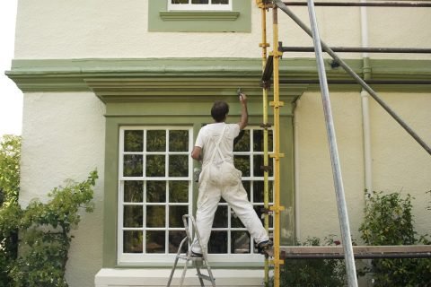 Painter Painter decorating a house exterior.
