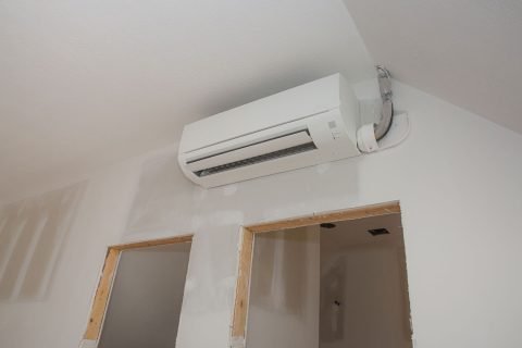 Unfinished-door-jam-and-an-AC-unit-mounted-on-the-living-room-wall Ductless Mini Split Systems Services In Stone Mountain GA