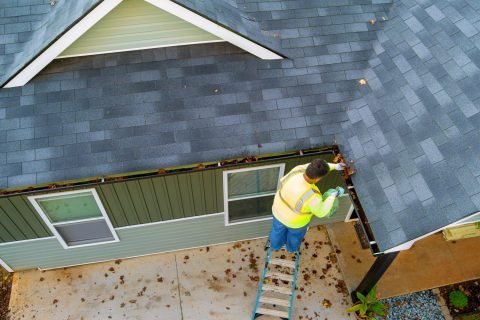 a-worker-is-cleaning-clogs-in-roof-gutter-drain-by-2023-11-27-05-24-29-utc-1-scaled-qug7fp3pscd5q33jiwxwc1ssbb940dwdrrt666mlu8 Roof Maintenance Raleigh, NC